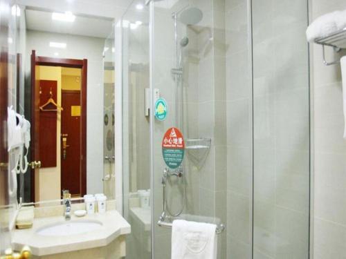 a bathroom with a glass shower and a sink at GreenTree Inn Suzhou Shihu Suli Road Express Hotel in Suzhou