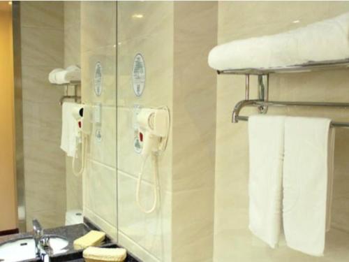 a bathroom with a phone on the wall next to a sink at GreenTree Inn Beijing Daxing Xingye Street Liyuan Business Hotel in Beijing