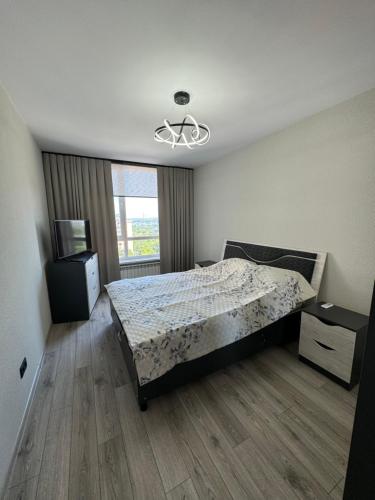 a bedroom with a bed and a dresser and a window at Marseille Apartment in Chişinău