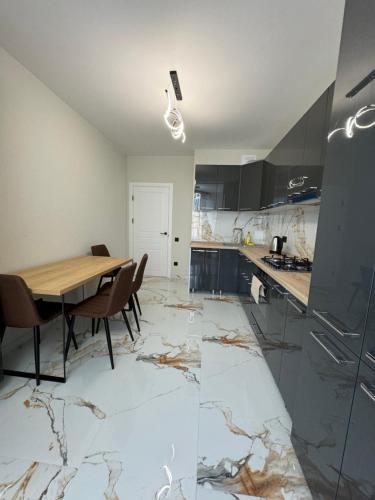 a kitchen with a table and chairs on a marble floor at Marseille Apartment in Chişinău
