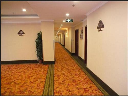 a hallway of a hotel with an orange carpet at GreenTree Inn Xuzhou High Speed Railway Station Express Hotel in Xuzhou