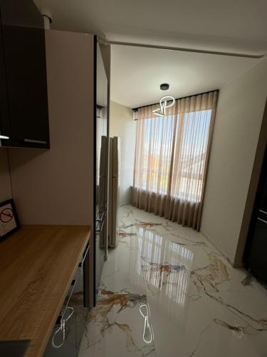 a room with a marble floor with a large window at Marseille Apartment in Chişinău
