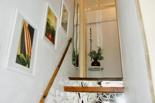 a hallway with a staircase with a mirror and paintings at The Corner House - Charming Rustic Home in the Heart of Monchique in Monchique