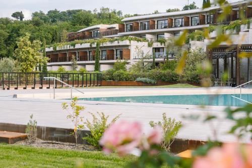 a hotel with a swimming pool in front of a building at A-ROSA Gardasee in Salò