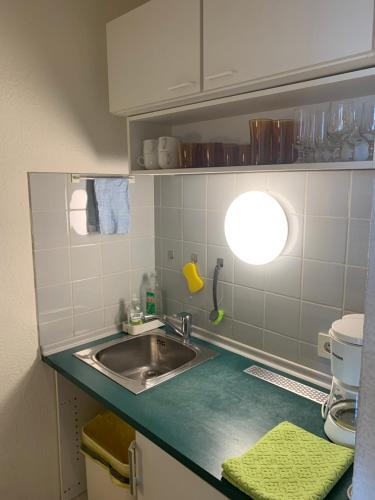 a kitchen with a sink and a light on the counter at Studio, Bergblick, 2 Betten, 1 Schlafsofa in Bad Reichenhall