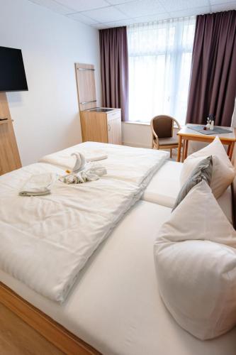 a large white bed in a hotel room at Sonnenschein Hotel & Apartments in Heilbad Heiligenstadt