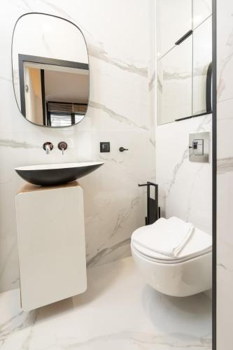 a white bathroom with a sink and a toilet at Olimpijska Premium Elite4Rent in Olsztyn