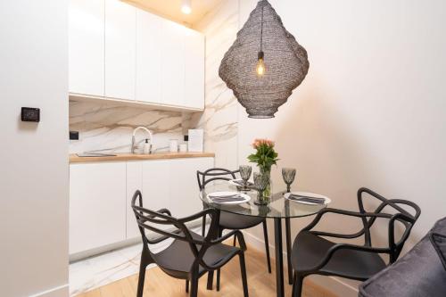 a kitchen and dining room with a table and chairs at Olimpijska Premium Elite4Rent in Olsztyn