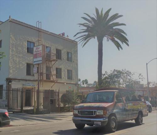 a truck driving down a street with a palm tree at Las Palmas Hotel in Los Angeles