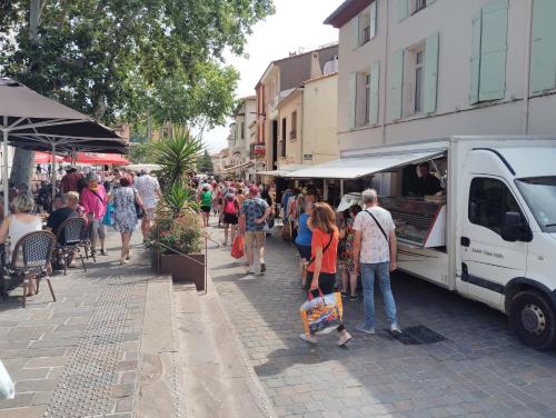 une foule de personnes marchant dans une rue près d'un food truck dans l'établissement appartement 4 personnes centre ville argeles sur mer petit prix, à Argelès-sur-Mer