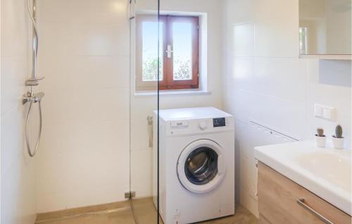 a bathroom with a washing machine and a sink at Schoenes Ferienhaus Straden in Straden