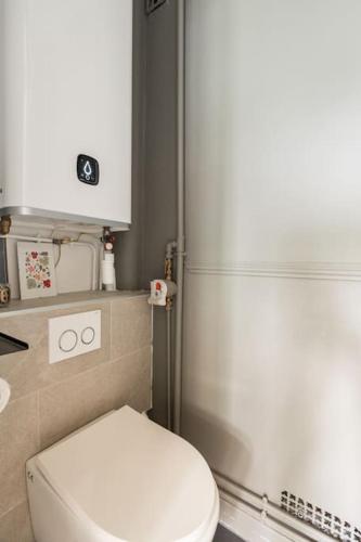 une salle de bain avec des toilettes blanches et une douche dans l'établissement Appartement cosy Bois colombes, à Bois-Colombes