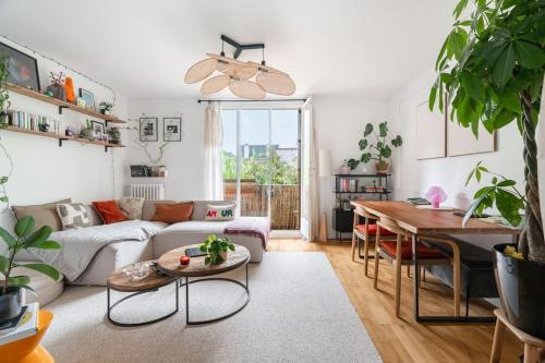 un salon avec un canapé et une table dans l'établissement Appartement cosy Bois colombes, à Bois-Colombes