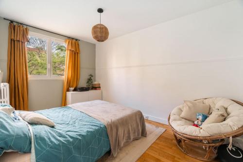 une chambre avec un lit et une chaise dans l'établissement Appartement cosy Bois colombes, à Bois-Colombes