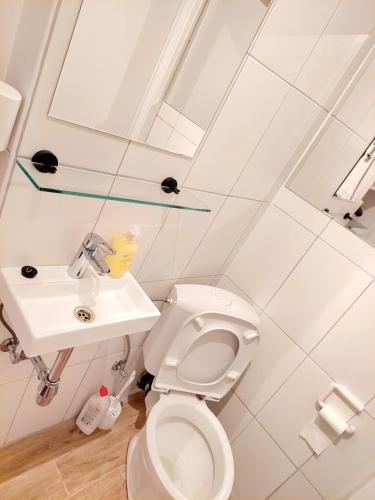 a white bathroom with a sink and a toilet at Maison LYDIE - Meublé de vacances 3 étoiles in Charleroi