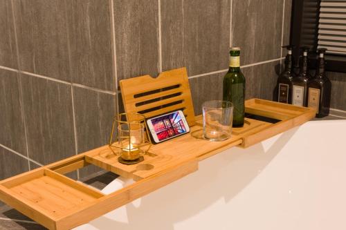 a wooden tray with wine bottles and glasses on a counter at FARMSTAY miyuki-street "Hotaru" in Kugumiya