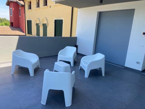 a group of white chairs and tables on a patio at Dormi-RE Affittacamere in Reggio Emilia