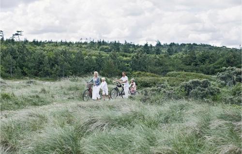 a family riding bikes on a trail in a field at Skærbæk Fritidscenter in Skærbæk
