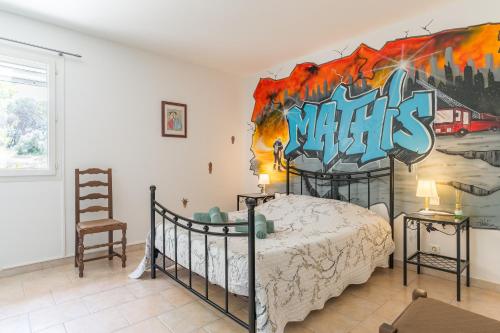 a bedroom with a bed with a painting on the wall at Mas Provençal in Saint-Rémy-de-Provence