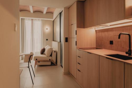 a kitchen with a sink and a chair in a room at Pau Suites in Villajoyosa