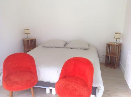 Schlafzimmer mit zwei roten Stühlen und einem Bett in der Unterkunft La maison du Verger in Brinon-sur-Sauldre