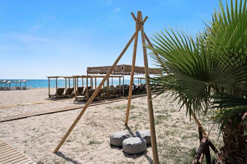 a beach with a palm tree and a building on the beach at Iguana studio 6 in Preveza