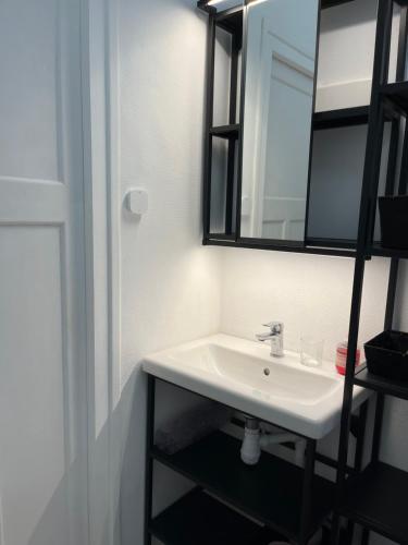 une salle de bain avec un lavabo et un miroir dans l'établissement KerKolina, à Cancale