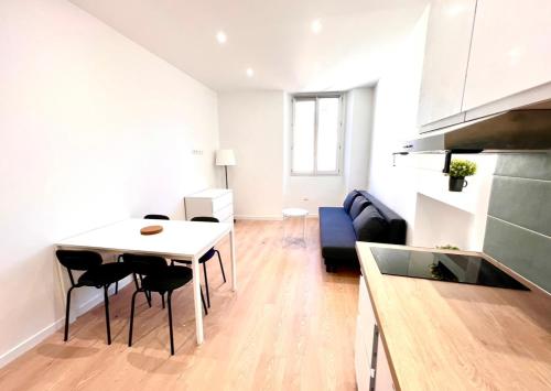 een keuken en woonkamer met een tafel en stoelen bij Collet Résidence in Nice