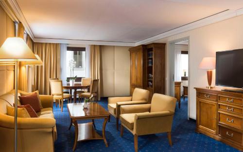 a hotel room with chairs and a television at Hilton Dresden an der Frauenkirche in Dresden