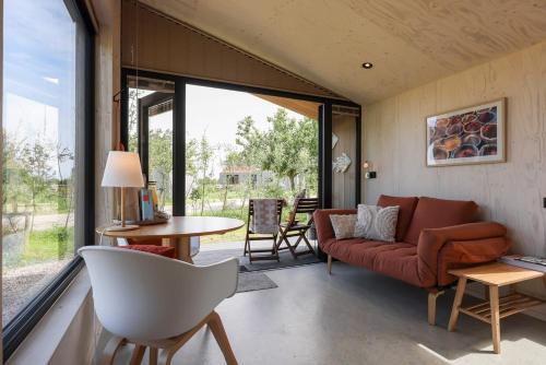 una sala de estar con un sofá y una mesa en Hello Zeeland - Tiny House Zeeuwse Liefde 13, en Westkapelle