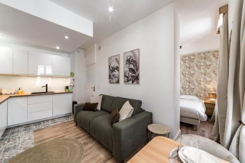 un salon avec un canapé et une cuisine dans l'établissement La palmeraie AIL, à Villeurbanne