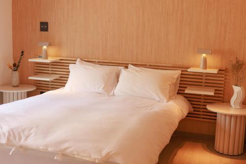 a large bed with white sheets and pillows at MKG Home・芝 in Tokyo