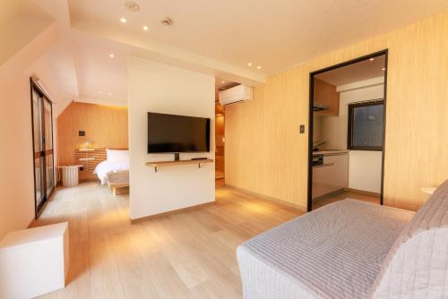 a bedroom with a bed and a flat screen tv at MKG Home・芝 in Tokyo