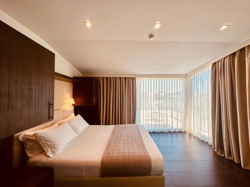 a hotel room with a bed and a large window at Hotel Miramare - SPA & Suites - Breakfast & Brunch Until 13-00 in Cervia