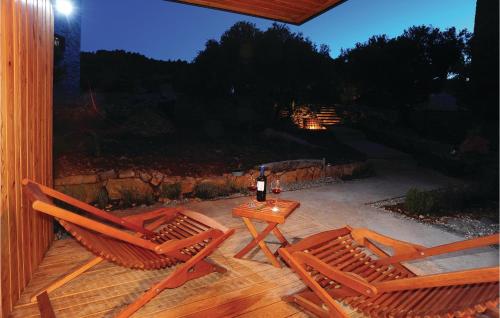 a patio with two chairs and a table with a bottle of wine at Amazing Home In Dragove in Dragove