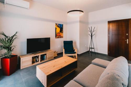 a living room with a couch and a tv at Charys Premium Home in Preveza