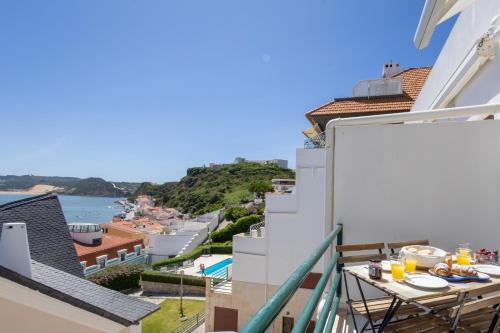 a balcony with a table and a view of the water at Baía - by Smarthomes in São Martinho do Porto