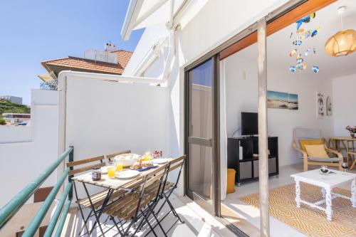 a room with a balcony with a table and chairs at Baía - by Smarthomes in São Martinho do Porto