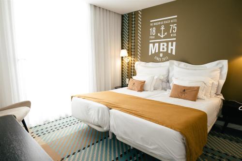 a hotel room with a large bed with a large window at Macarico Beach Hotel in Praia de Mira