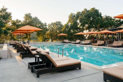a swimming pool with chairs and umbrellas at Carmel Valley Ranch, in The Unbound Collection by Hyatt in Carmel Valley