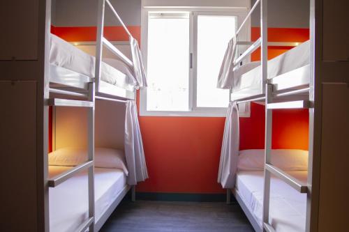 two bunk beds in a room with a window at room00 Valencia Hostel in Valencia