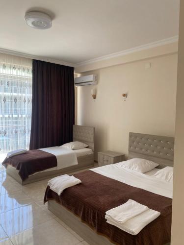 a hotel room with two beds and a window at SUNSHINE Hotel Kvariati in Kvariati
