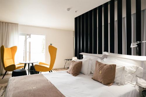 a bedroom with a white bed and a black and white wall at Macarico Beach Hotel in Praia de Mira