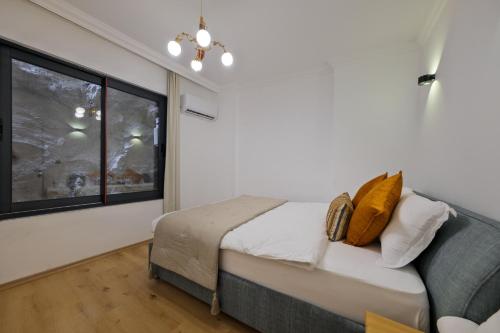 a bedroom with a bed and a window at Körfez Residence in Fethiye