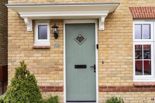 a brick house with a green door and windows at 3 Bedroom 4 Bathroom House Goodwood Chichester in Chichester