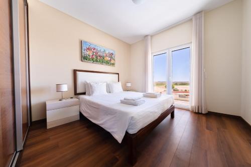 une chambre avec un lit et une grande fenêtre dans l'établissement Baleal Deluxe Apartments, à Baleal