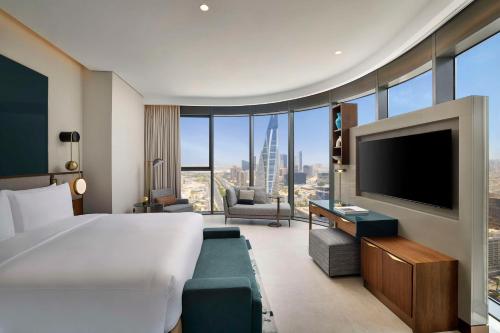 a hotel room with a large bed and a flat screen tv at Conrad Bahrain Financial Harbour in Manama