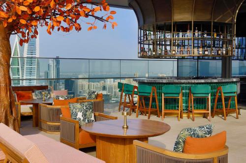 a restaurant with tables and chairs and a view of the city at Conrad Bahrain Financial Harbour in Manama