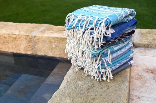 une pile de serviettes posée sur un mur de pierre dans l'établissement La maison de Flore, à Pernes-les-Fontaines