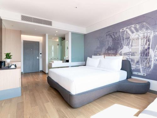 a bedroom with a bed and a painting on the wall at Novotel Phnom Penh BKK 1 in Phnom Penh